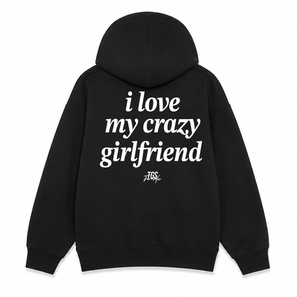 Black pullover hoodie shown from the front and back on a white background. The front has small white text reading 'I love my crazy girlfriend' on the left chest, and the back has large white text reading 'i love my crazy girlfriend' with a small script mark below.