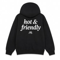 Black pullover hoodie shown from the front and back on a plain white background. The front has a small white 'hot & friendly' logo on the left chest, and the back has a large white 'hot & friendly' logo with a smaller 'TSG' mark below.