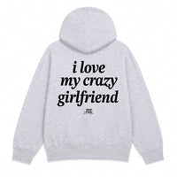 A light heather gray pullover hoodie shown from both the front and back. The front features a small black text graphic on the left chest reading 'i love my crazy girlfriend'.
